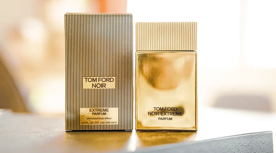 عطر Noir از برند Tom ford در کنار جعبه بر روی میز سنگی طوسی رنگ